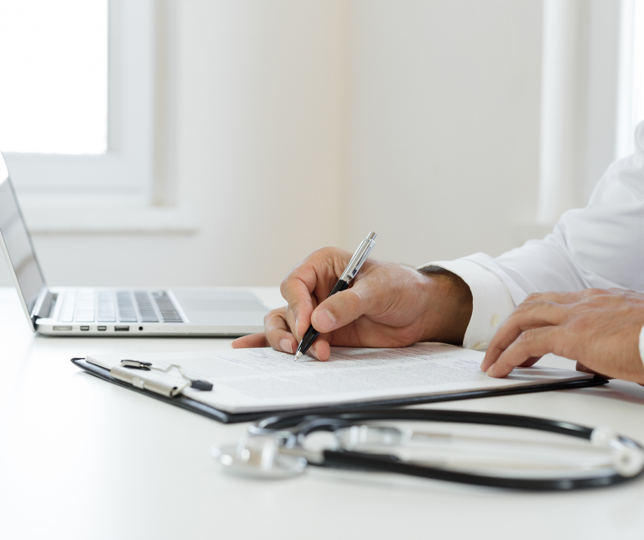 Doctor filling in a form on a clipboard