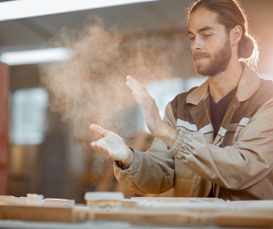 carpenter clapping hands to remove wood dust