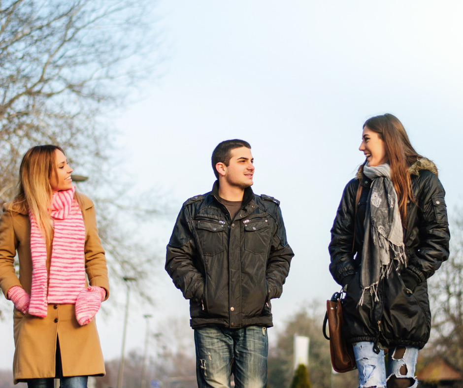 Two women and a man walking and walking