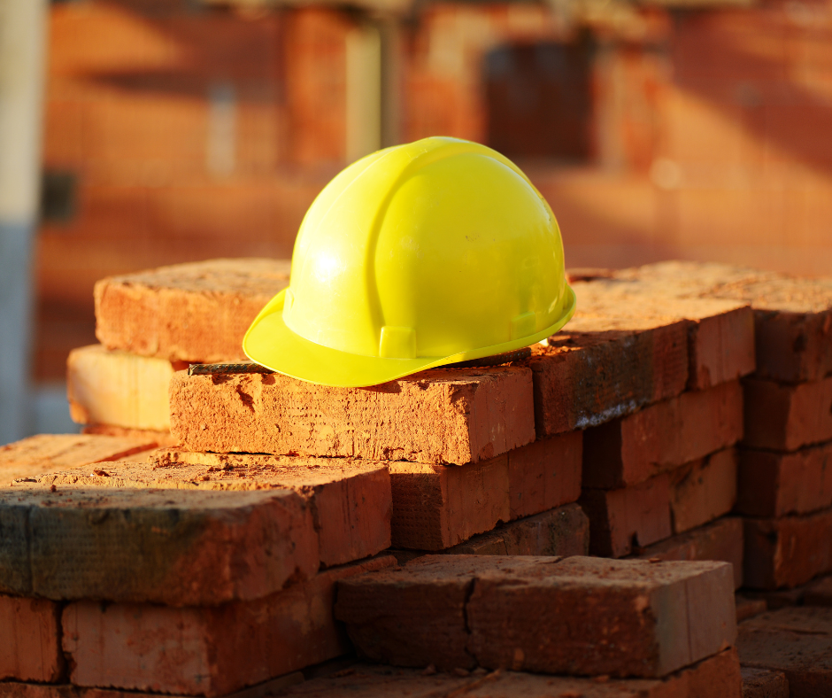Yellow safety helmet on a pile of bricks