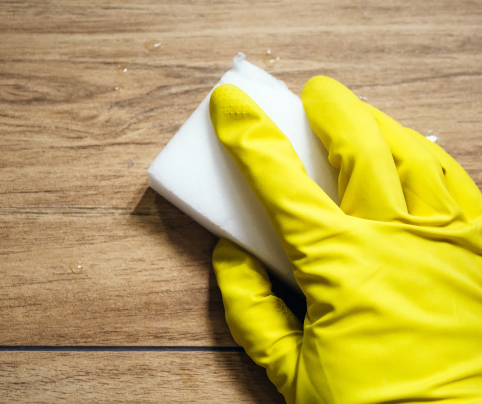 yellow gloved hand wiping a surface